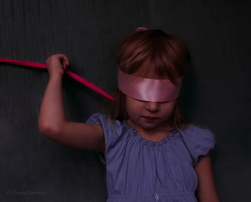 A photo of a child with a blindfold, illustrating how they might feel darkness.